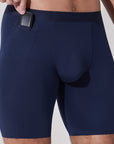 Man placing car key into pocket of navy blue boxer briefs with patented pocket