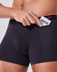 Man placing condom into pocket of black boxer briefs with patented pocket