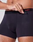 Man placing car remote into pocket of black boxer briefs with patented pocket