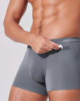 Man placing earbuds into patented pocket in boxer briefs for secure storage