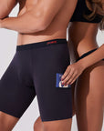 Woman placing passport into pocket of black boxer briefs with patented pocket