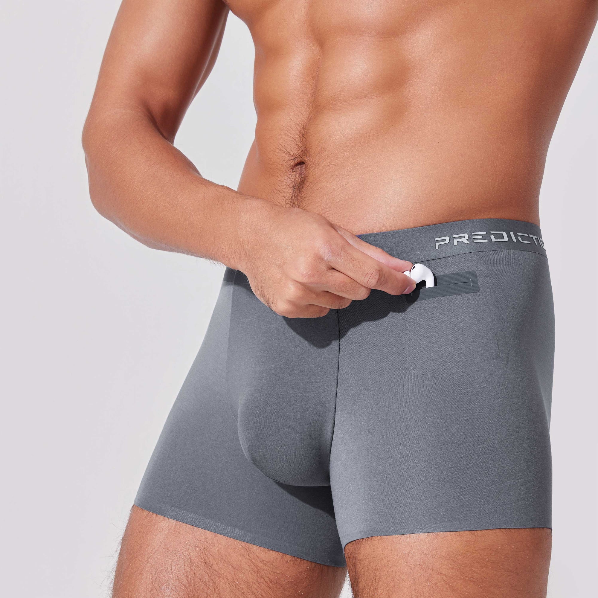 Man placing earbuds into patented pocket in boxer briefs for secure storage