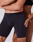Woman reaching into the hidden pocket of black boxer briefs showing discreet pocket access