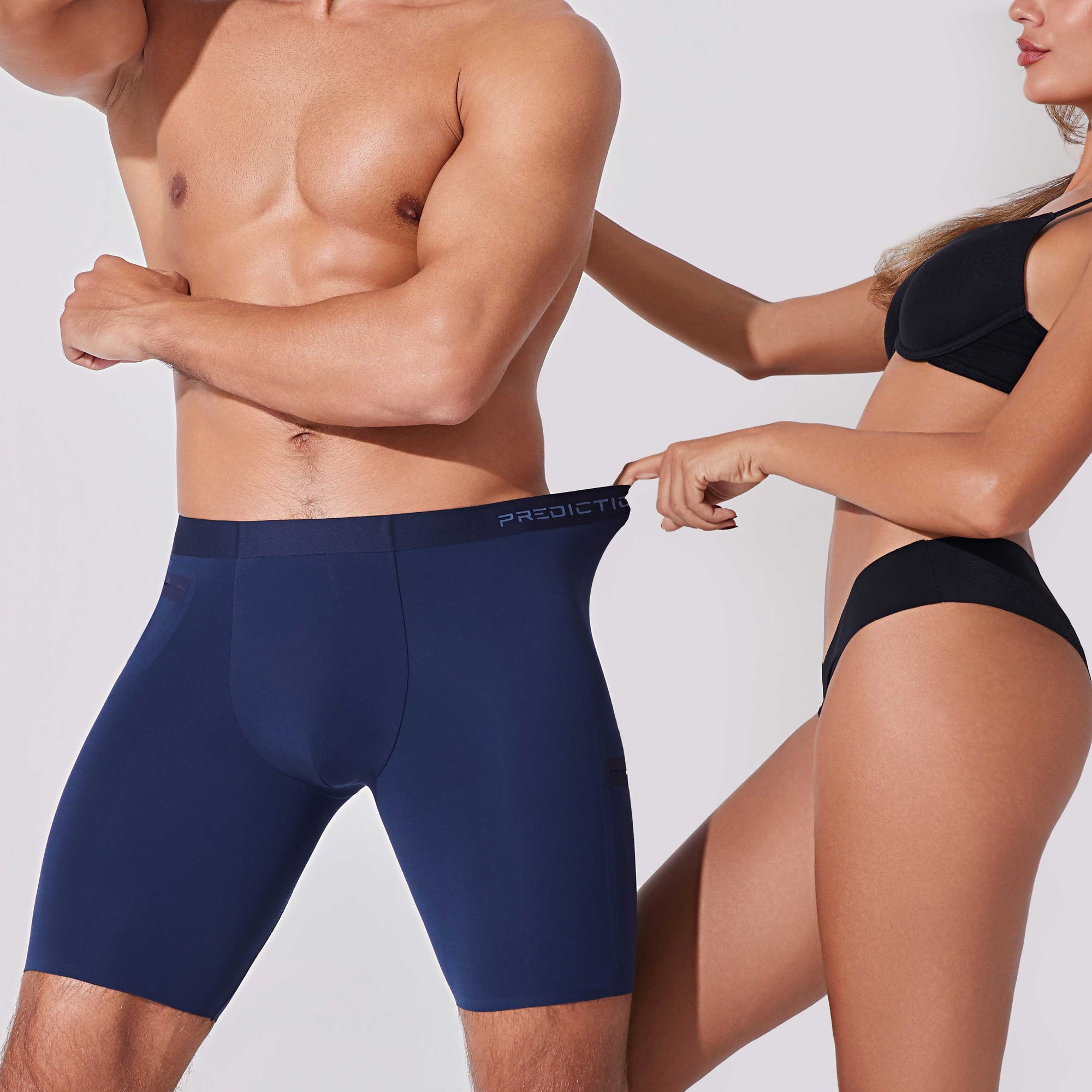 Woman pulling the waistband of navy blue boxer briefs showing flexible stretch and comfortable fit