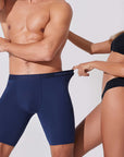 Woman pulling the waistband of navy blue boxer briefs showing flexible stretch and comfortable fit